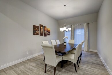 Formal dining area features: Chandelier, wood tiled flooring, rays of natural light and abundant space