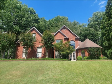 View of front of house with french doors, brick siding, and a front yard