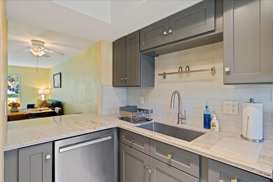 The updated kitchen boasts solid wood shaker-style cabinets, granite countertops, a large farmhouse sink, and a tasteful tile backsplash in clean, modern colors. A convenient pass-through to the dining area provides the perfect spot to pull up a stool for a quick, casual meal.