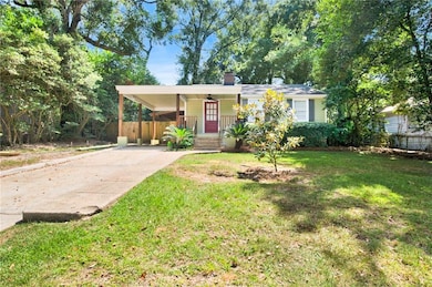Single story home with a porch, driveway, an attached carport, and a chimney
