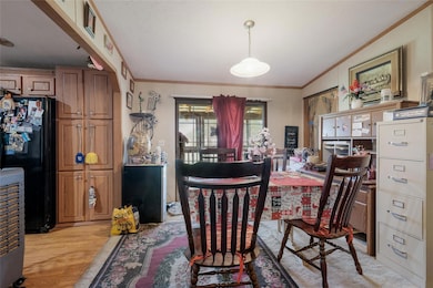 Dining room with ornamental molding and light woo