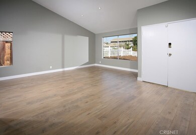 The family room is bathed in natural light from a multitude of windows and is further accented by a two-toned designer paint scheme, soaring ceilings, new recessed LED lighting and complementary new modern wood laminate floors; plus easy access to th