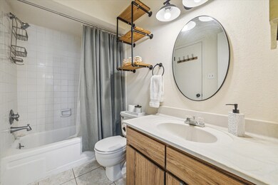 Bathroom has updated lighting and shelving.