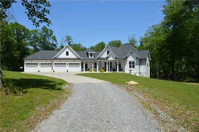 View of front of property featuring gravel driveway, a porch, a front yard, and a shingled roof