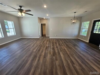 Unfurnished room with healthy amount of natural light, recessed lighting, dark wood-type flooring, a chandelier, and a ceiling fan