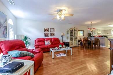 Living area with light wood finished floors and a ceiling fan