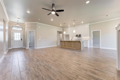 Unfurnished living room featuring crown molding, b