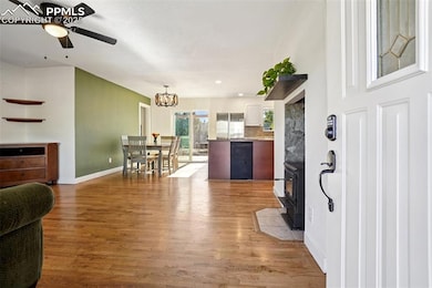 Foyer entrance featuring light wood finished floors, beverage cooler, a chandelier, and a wood stove