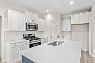 Kitchen with light wood-type flooring, backsplash,