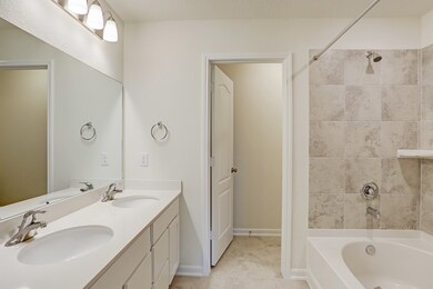 Tiled master bath with double sinks.