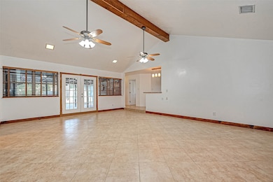Family room with double doors to the back covered patio.