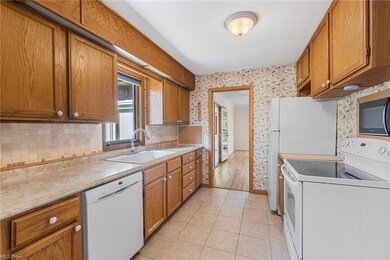 Kitchen with white appliances, tile backsplash, an