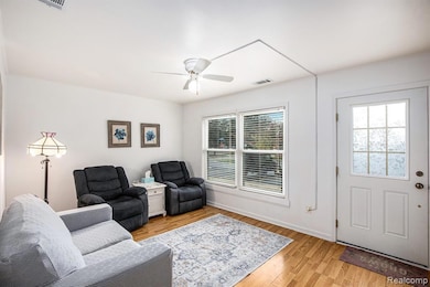 Living room featuring healthy amount of natural light, light wood-style floors, and a ceiling fan