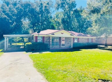 Single story home featuring a front yard and a car