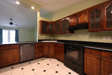 Kitchen with range, dishwasher, dark countertops, 