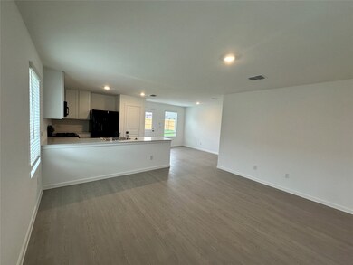Unfurnished living room featuring recessed lighting, wood finished floors, a sink, baseboards, and visible vents