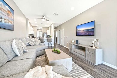 Living room with dark wood finished floors, recessed lighting, and ceiling fan