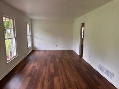 Empty room with dark wood finished floors and plenty of natural light