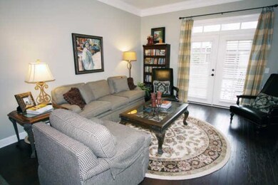 The spacious living room has hardwood floors and lots of good natural light flowing into the space from the windows.