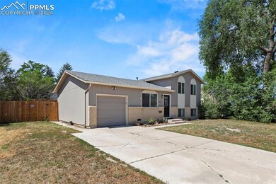 Tri-level home with a garage and a front lawn
