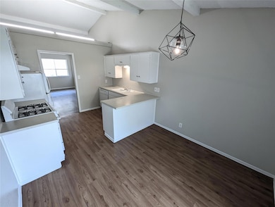 Kitchen with white cabinets, a peninsula, light c