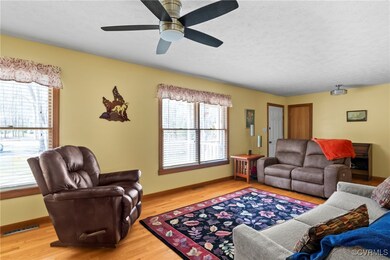Living room with baseboards, a textured ceiling, l