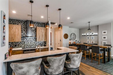 Kitchen featuring wall chimney range hood, hanging