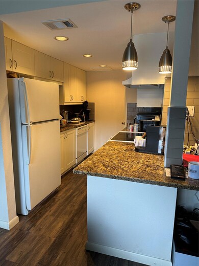 Kitchen with refrigerator, cooktop, visible vents