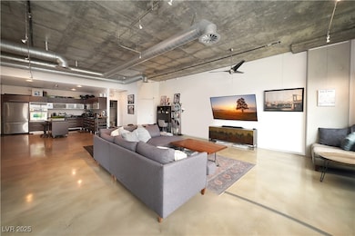 Living area featuring finished concrete floors, ce