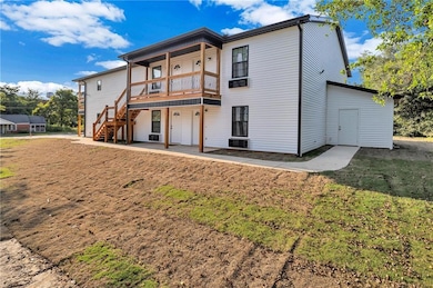 Rear view of property with stairway and a lawn