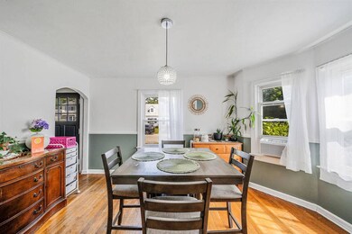 Dining space with arched walkways, light wood finished floors, cooling unit, and ornamental molding