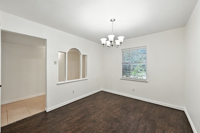 Empty room featuring wood finished floors and a chandelier