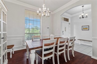 Formal Dining room features crown moulding, decorative light and laminate wood flooring.