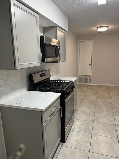 Kitchen featuring decorative backsplash, gray cab