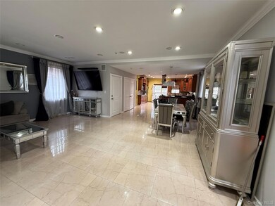 Kitchen featuring crown molding, a kitchen bar, pendant lighting, healthy amount of natural light, and open floor plan