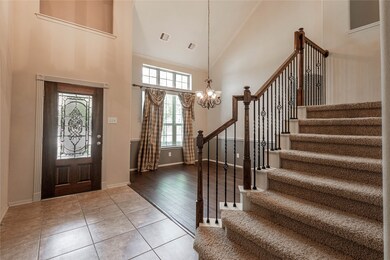 View of the formal dining and entrance with glass leaded door and high ceiling.