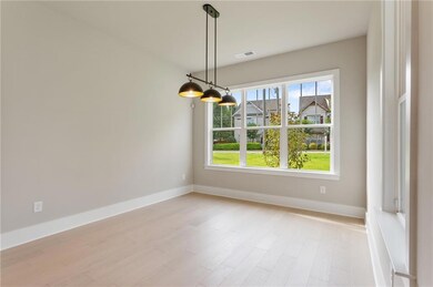 Unfurnished dining area with baseboards and light wood-type flooring