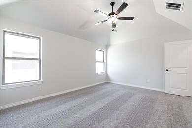 Spare room featuring a ceiling fan, lofted ceiling, carpet flooring, and baseboards