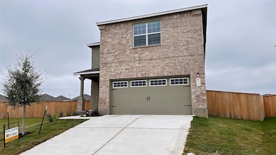View of front facade with brick siding, a garage,