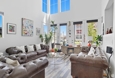 Living room with hardwood / wood-style floors and a high ceiling
