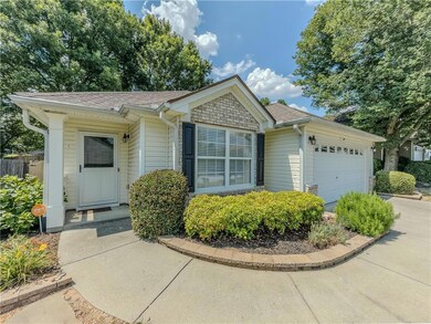 Single story home featuring a garage, a shingled roof, and concrete driveway