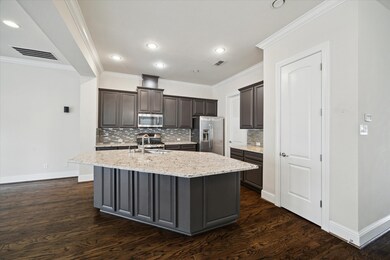 This kitchen features dark cabinetry with a modern