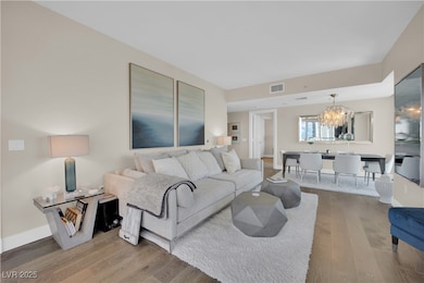 Living room with baseboards, visible vents, wood f