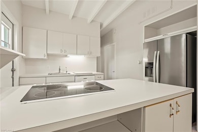 Kitchen featuring beamed ceiling, stainless steel 