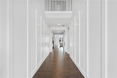 Hall with recessed lighting, dark wood finished floors, and a decorative wall