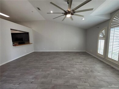 Unfurnished living room featuring lofted ceiling, recessed lighting, baseboards, ceiling fan, and visible vents