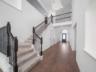The elegant staircase and open upper landing add a touch of grandeur while connecting the home’s spacious main and upper levels.