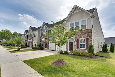 View of property featuring stone siding, an attach
