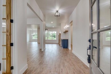 Foyer entrance with light wood-style flooring, baseboards, and a chandelier