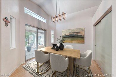 Dining area with light wood-style floors, a chande